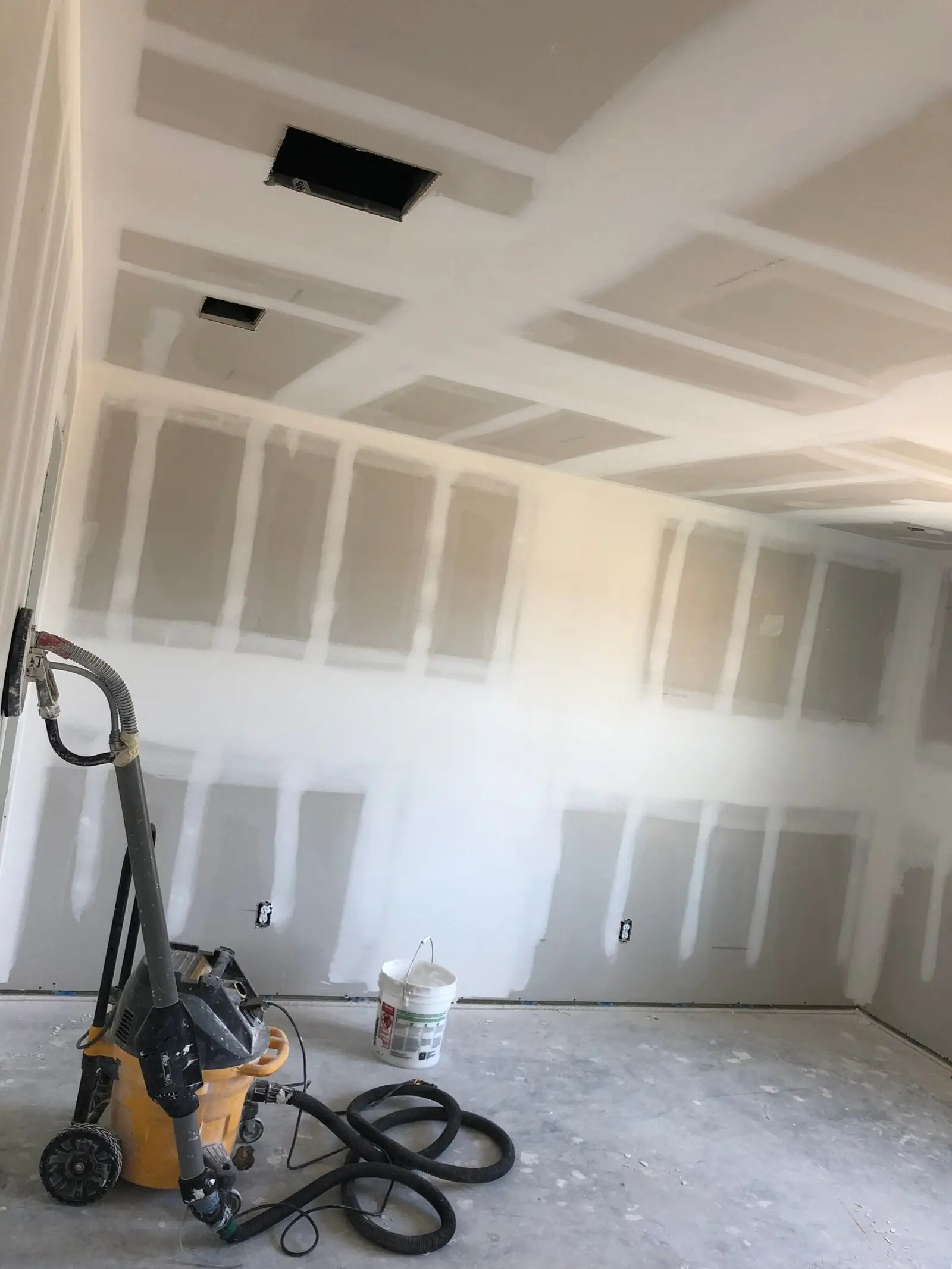 Drywall contractor in Houston, TX finishing taped and floated walls on a jobsite